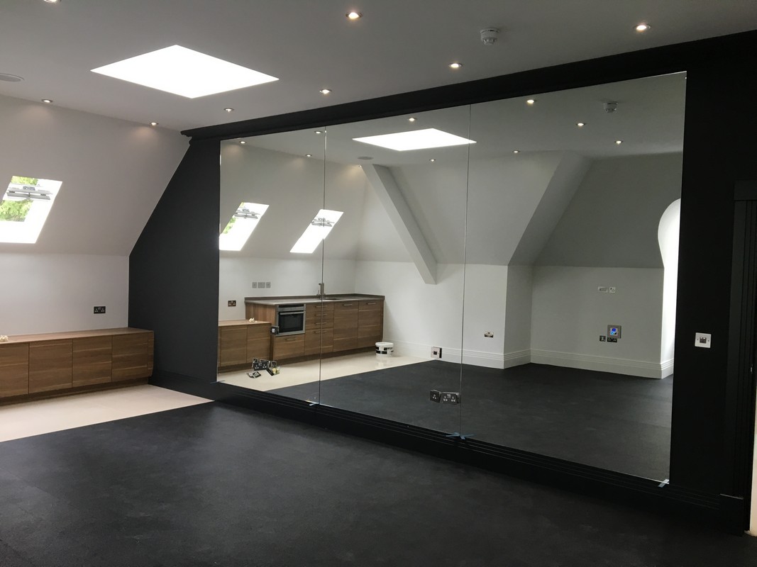 Frameless glass wall dividing loft conversion in Barnet